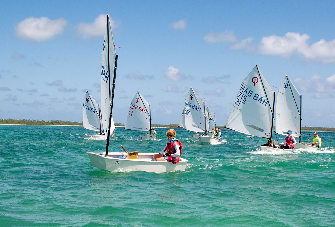 Young sailors racing Optimist dinghies together in Savannah Sound