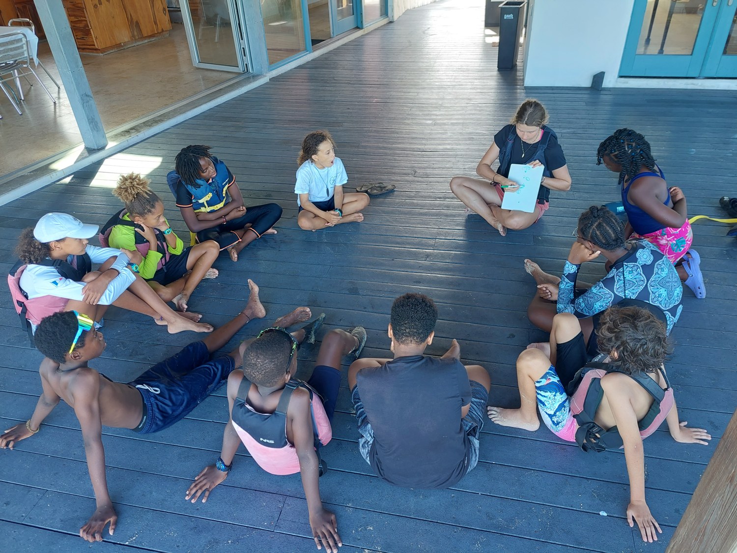 An ESA volunteer leading a shoreside learning session with young sailors